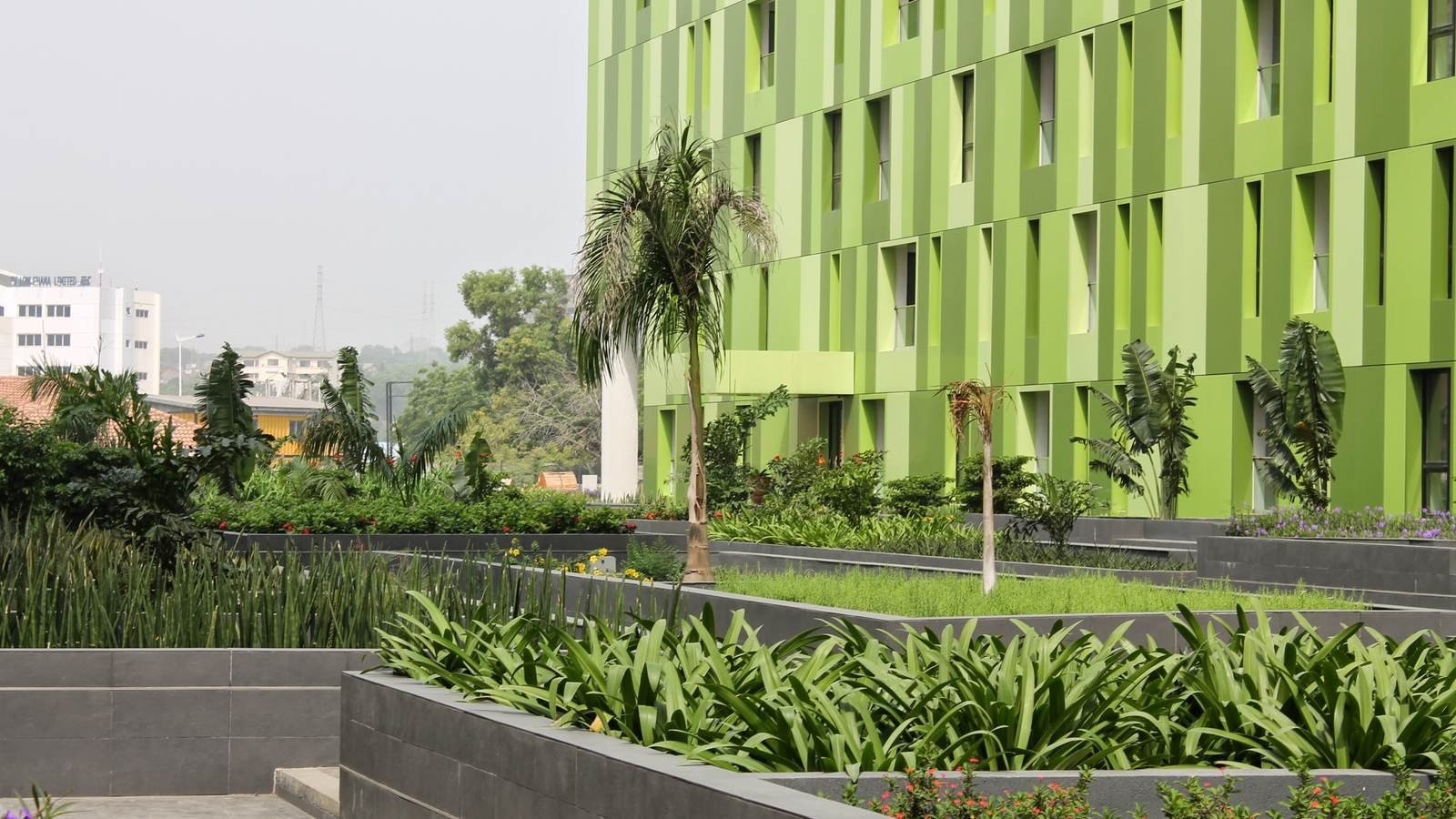 A contemporary commercial building in Accra with planted landscaping along its frontage