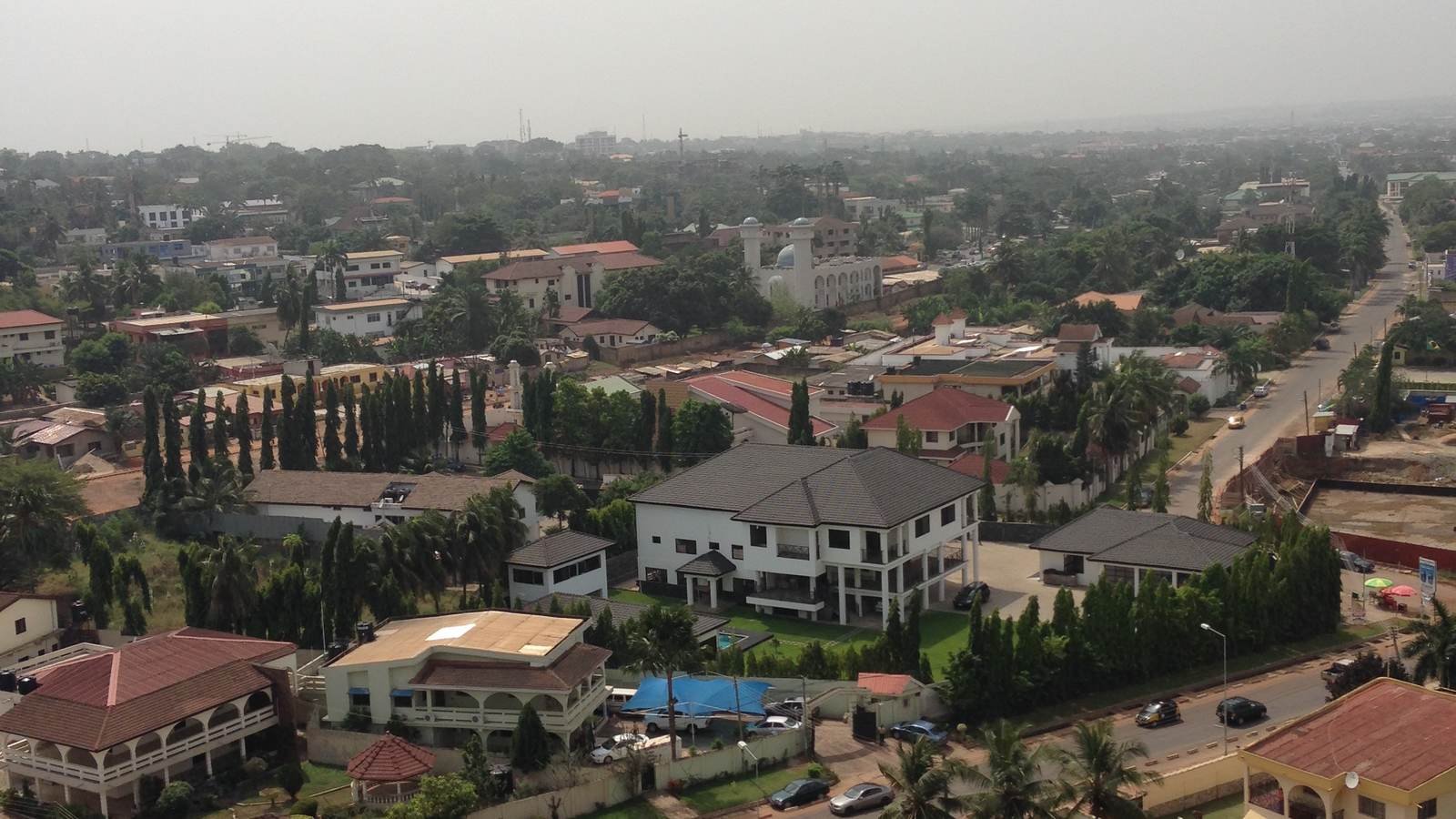 Rooftops and tree-lined streets of an Accra neighbourhood seen from above